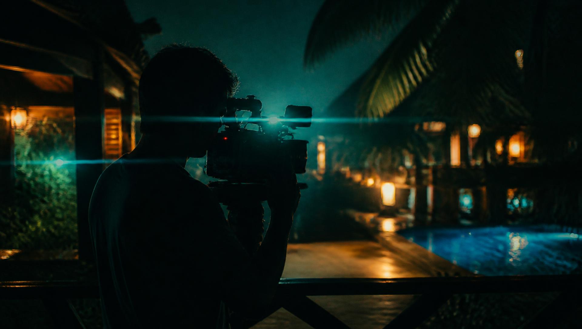 Cinematographer filming on location at night
